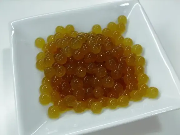Small spheres of tea made by spherification.