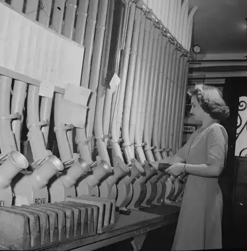 Pneumatic tube: Washington, D.C. Miss Helen Ringwald works with the pneumatic tubes through which messages are sent to branches in other parts of the city for delivery
