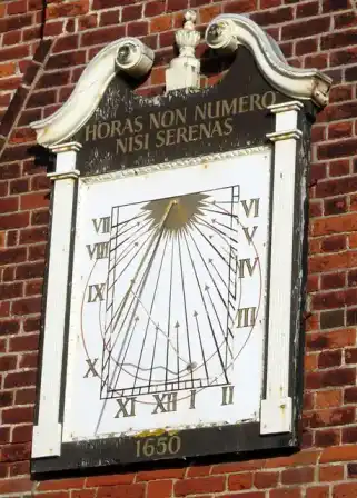 A sundial mounted on a building.